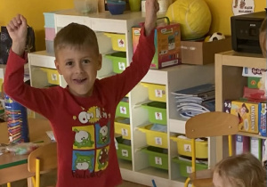 Dziewczynka wystukuje rytm na patyczkach a chłopiec improwizuje ruchem