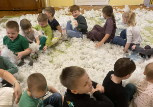 Dzieci siedząc w kole udają że uczestniczą w kuligu