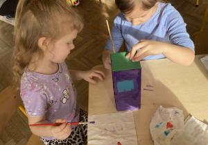 Dziewczynki wspólnie malują element pracy