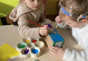 Dwie dziewczynki malują farbami