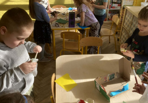 Dzieci pracują w grupach przy stolikach