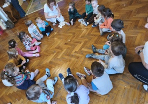 Dzieci siedzą w kole.