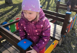 Dziewczynka bawi się w drewnianej ciuchci.