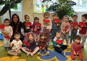 Dzieci pozują do zdjęcia z Pania Dyrektor i serduszkami.