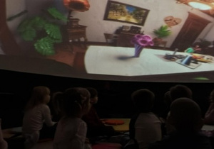 Dzieci oglądają baję edukacyjną pod kopułą.