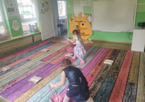 Dzieci świętują urodziny. Bawią się na dywanie i wykonują różne zadania