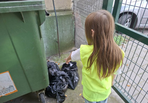 Dzieci biorą udział w Akcji Sprzątania Świata i sprzątają oo okolice przedszkola