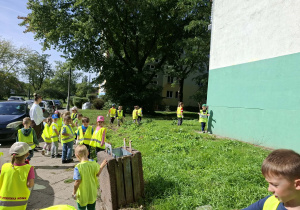Dzieci biorą udział w Akcji Sprzątania Świata i sprzątają oo okolice przedszkola