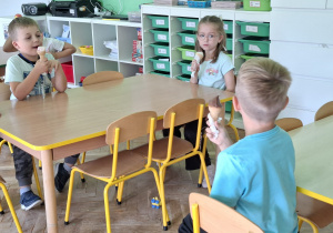Dzieci jedzą lody z okazji dnia Przedszkolaka