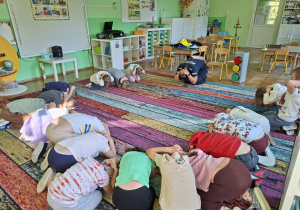 Dzieci biorą udział w zajęciach z przedstawicielami policji. Przypominają sobie zasady bezpieczeństwa na drodze
